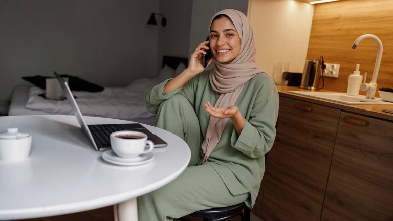 A Cozy Home Office Setup Featuring a Woman Engaged in a Phone Conversation While Using a Laptop